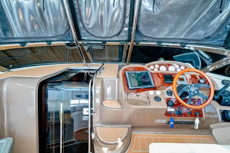 Slide: The Image of 2006 Regal 3560 COMMODORE yacht cockpit with modern controls and wooden steering wheel. - 16