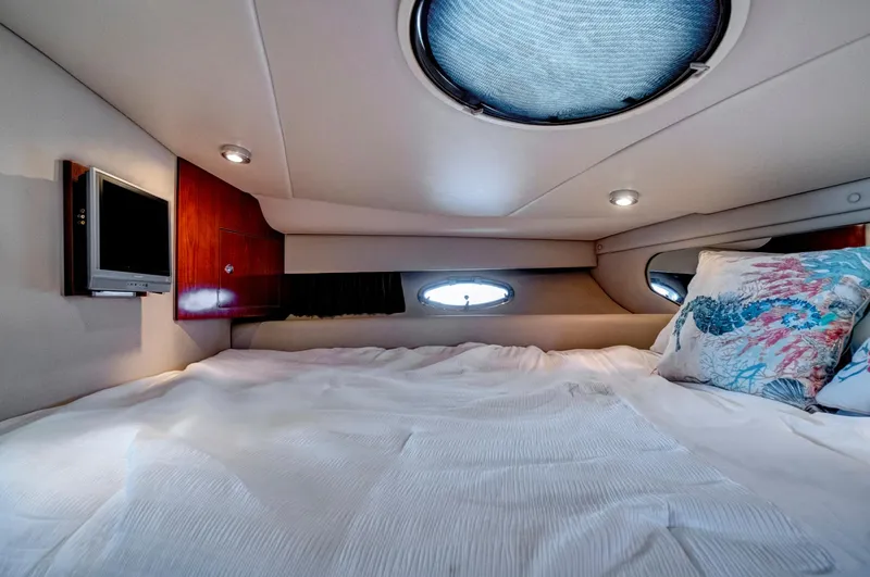 Slide: The Image of 2006 Regal 3560 COMMODORE cabin interior with bed, portholes, and TV. - 19