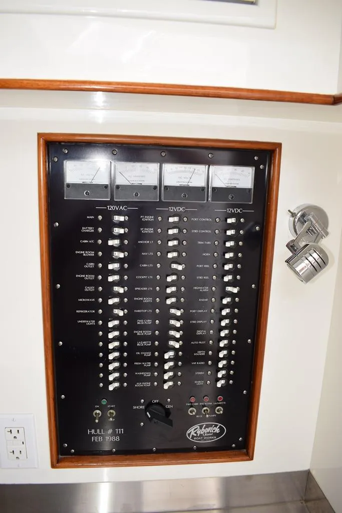 Slide: The Image of Electrical panel of a 1988 Rybovich Express Walkaround boat with switches and meters. - 12