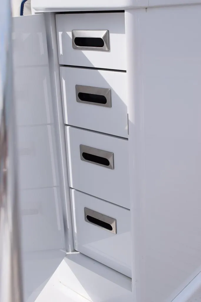 Slide: The Image of 1988 Rybovich Express Walkaround boat storage drawers, sleek white design with metal handles. - 15