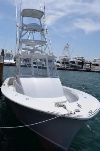 Slide: The Image of 1988 Rybovich Express Walkaround boat docked at marina under clear sky. - 18