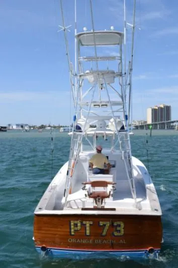Slide: The Image of 1988 Rybovich Express Walkaround boat on water, rear view, labeled "PT 73" from Orange Beach, AL. - 19
