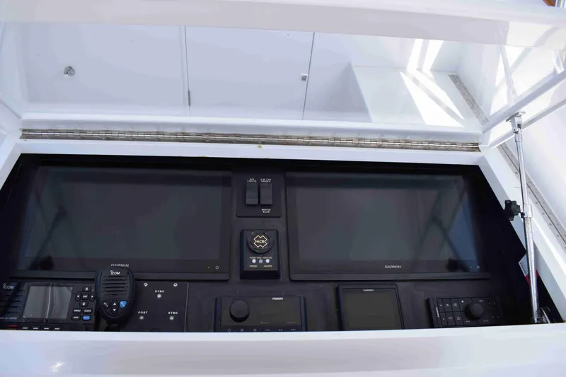 Slide: The Image of 1988 Rybovich Express Walkaround dashboard with modern navigation and communication equipment. - 4