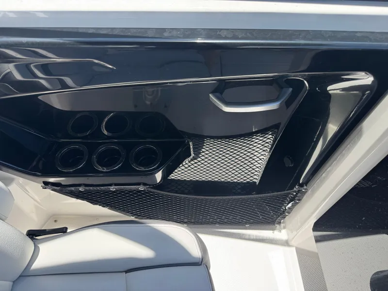 Slide: The Image of 2025 Yamaha AR250 boat interior with cup holders and storage net. - 18