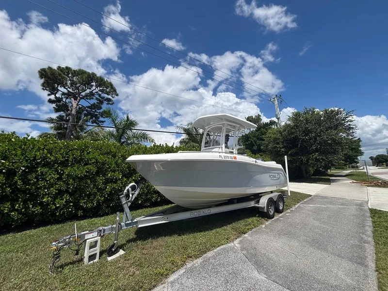 The Image of 2019 Robalo R222 Center Console boat on trailer, parked outdoors under blue sky. - 1