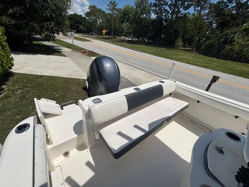 Slide: The Image of 2019 Robalo R222 Center Console boat with seating and outboard motor, parked near a road. - 11