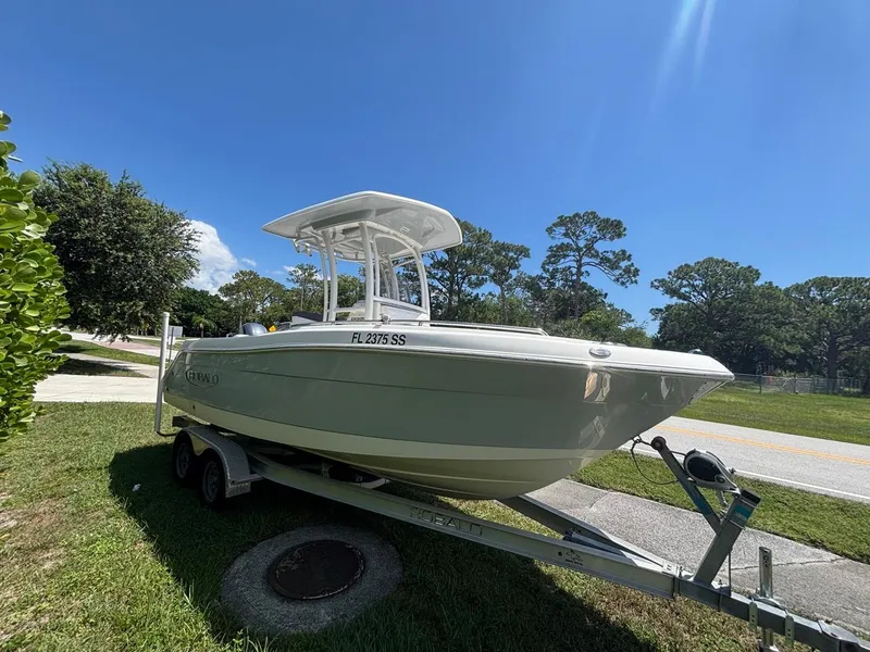 Slide: The Image of 2019 Robalo R222 Center Console boat on trailer under clear blue sky. - 3