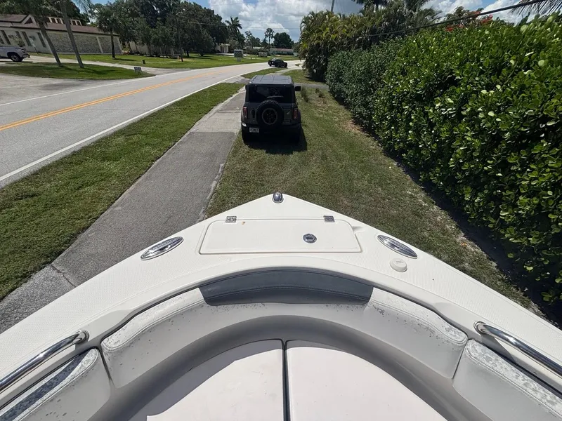 Slide: The Image of 2019 Robalo R222 Center Console boat parked on roadside near greenery. - 4
