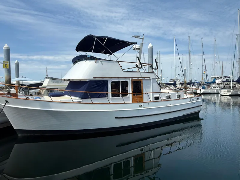 The Image of 1978 DeFever 39 yacht docked in marina, surrounded by sailboats under a clear sky. - 1