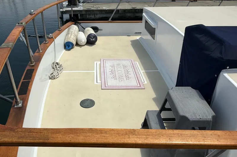Slide: The Image of 1978 DeFever 39 boat deck with welcome mat, fenders, and wooden railings. - 11