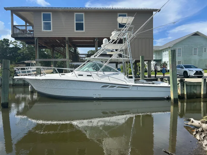 The Image of 2006 Rampage EXPRESS boat docked near waterfront homes. - 1