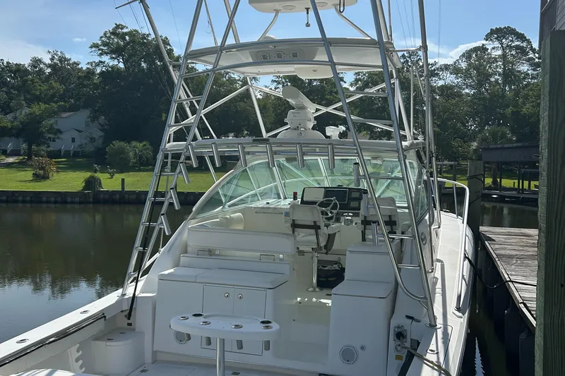 Slide: The Image of 2006 Rampage EXPRESS boat docked, featuring a spacious cockpit and fishing tower. - 25