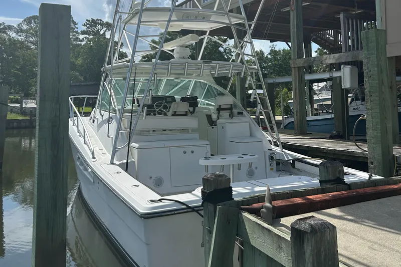 Slide: The Image of 2006 Rampage EXPRESS boat docked at marina, featuring sleek design and fishing equipment. - 3
