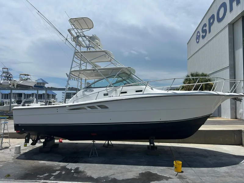 Slide: The Image of 2006 Rampage EXPRESS boat on dry dock near a large building, clear sky background. - 39