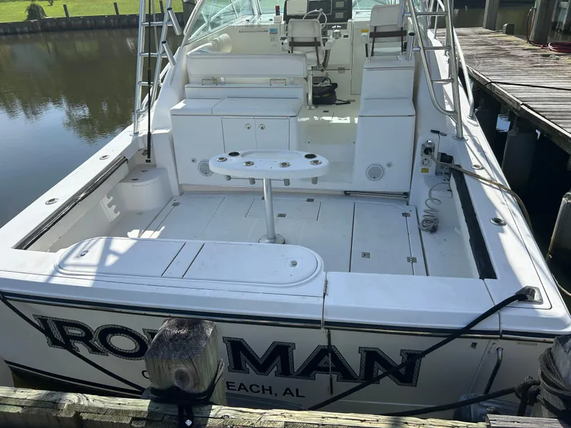 Slide: The Image of 2006 Rampage EXPRESS boat docked, featuring spacious deck and seating area. - 4