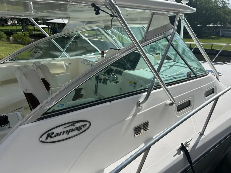 Slide: The Image of 2006 Rampage EXPRESS boat with sleek design and spacious cockpit, docked near greenery. - 9