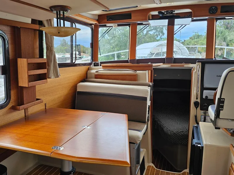 Slide: The Image of Interior of 2014 Ranger Tugs 31-CB boat, featuring wood finishes and seating area. - 19