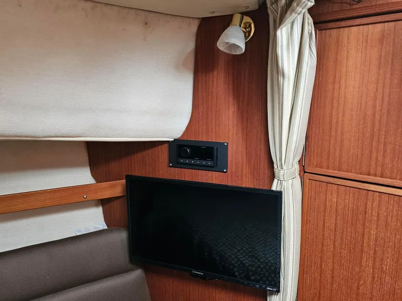 Slide: The Image of Interior of 2014 Ranger Tugs 31-CB with TV, wood paneling, and curtain. - 23