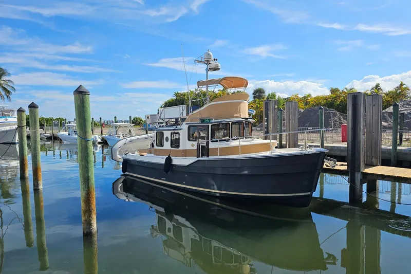 Slide: The Image of 2014 Ranger Tugs R 31 docked at a marina under a clear blue sky. - 24