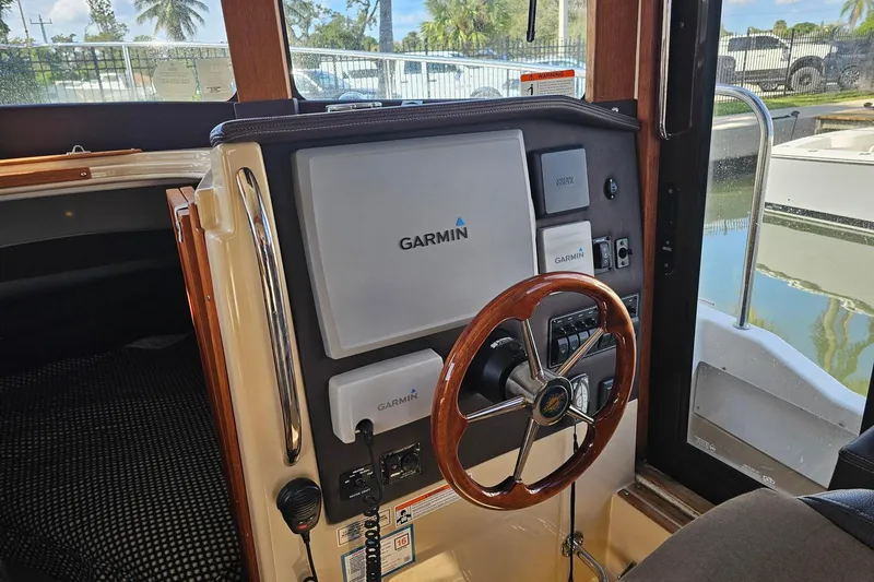 Slide: The Image of 2014 Ranger Tugs R 31 helm with Garmin navigation system and wooden steering wheel. - 32