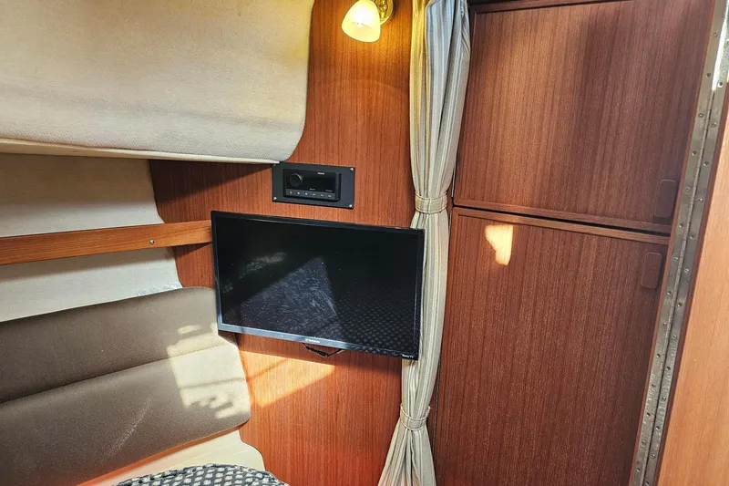 Slide: The Image of Interior of 2014 Ranger Tugs R 31 with TV, wood paneling, and cozy seating. - 40