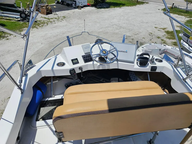 Slide: The Image of 2014 Ranger Tugs 31-CB helm with Garmin navigation, beige seating, and steering wheel. - 7