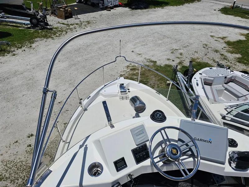 Slide: The Image of 2014 Ranger Tugs 31-CB boat helm with Garmin navigation system, docked on gravel. - 9