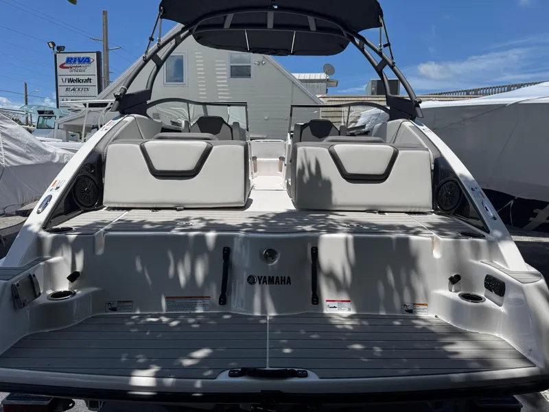 Slide: The Image of 2025 Yamaha AR250 boat with spacious seating and sleek design, docked under clear skies. - 1