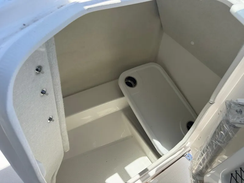 Slide: The Image of 2025 Yamaha Boats AR250 storage compartment interior with drain plug. - 15