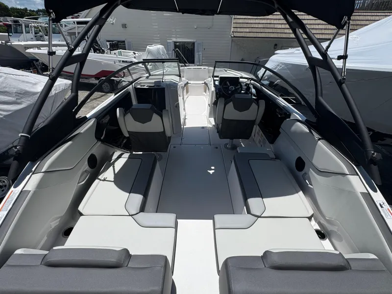 Slide: The Image of 2025 Yamaha Boats AR250 interior with seating and steering wheel, docked outdoors. - 2
