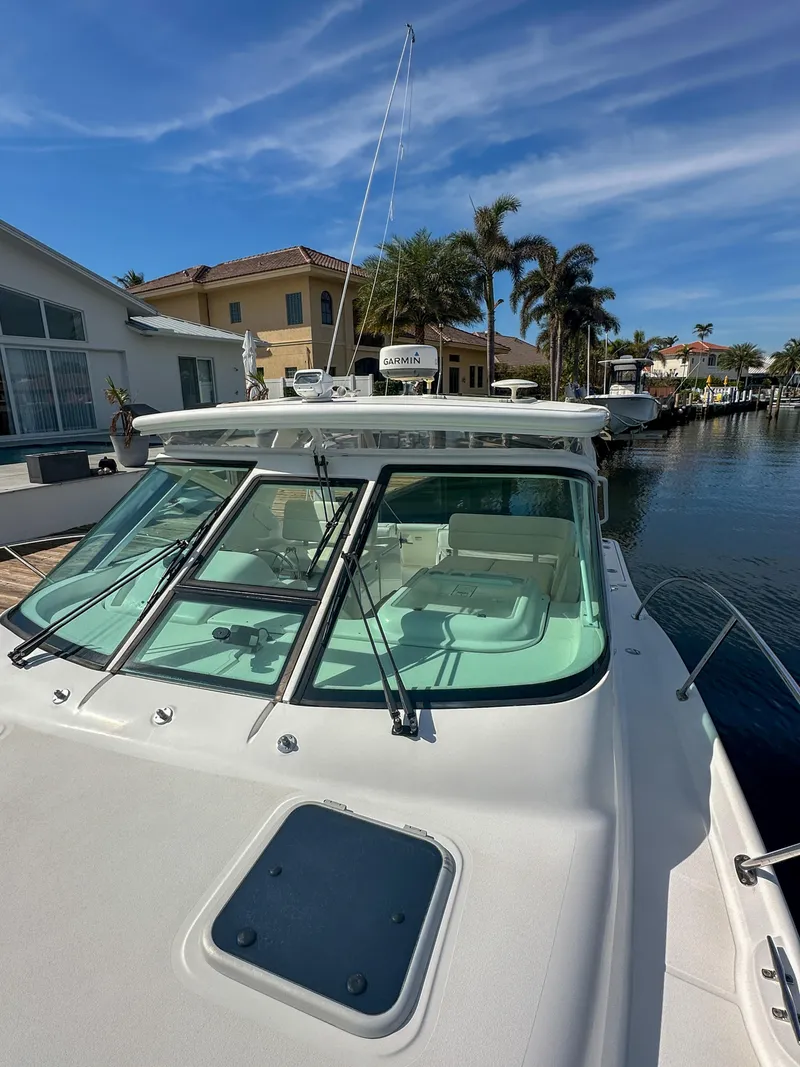 Slide: The Image of 2006 Tiara Yachts 3200 Open docked near waterfront homes under clear skies. - 11