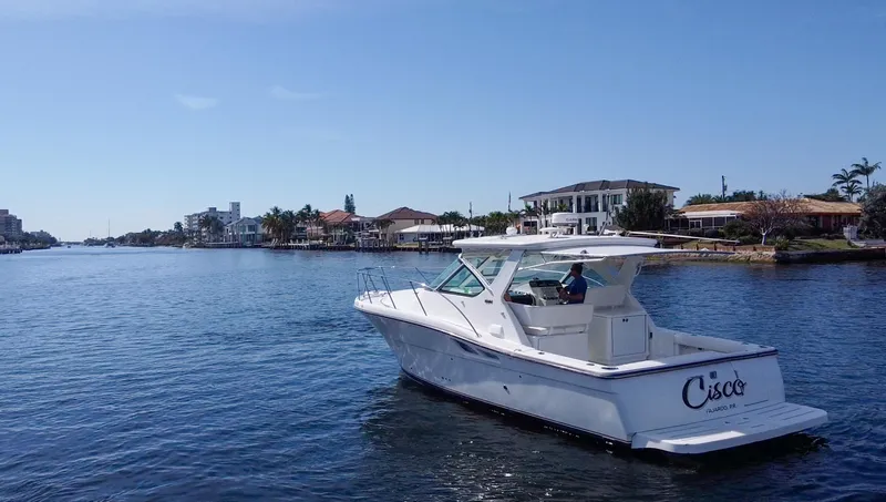 Slide: The Image of 2006 Tiara Yachts 3200 Open cruising on a sunny waterfront with houses in the background. - 2