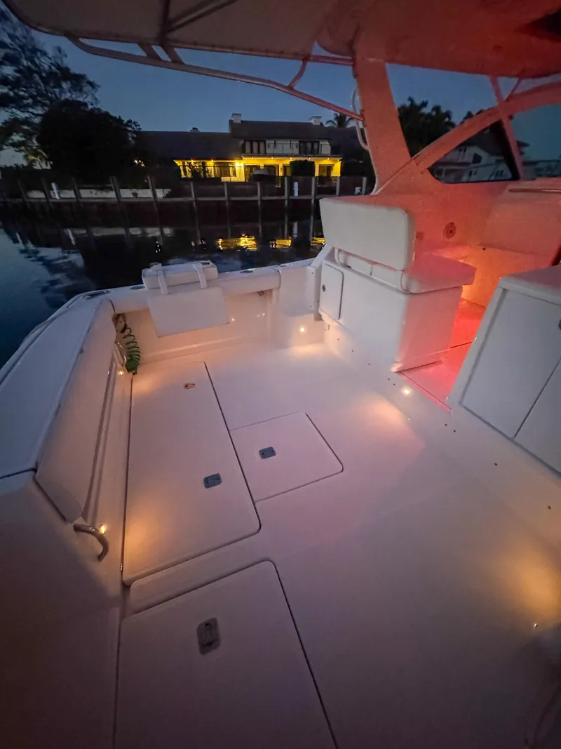 Slide: The Image of 2006 Tiara Yachts 3200 Open boat deck illuminated at dusk, docked near waterfront home. - 21