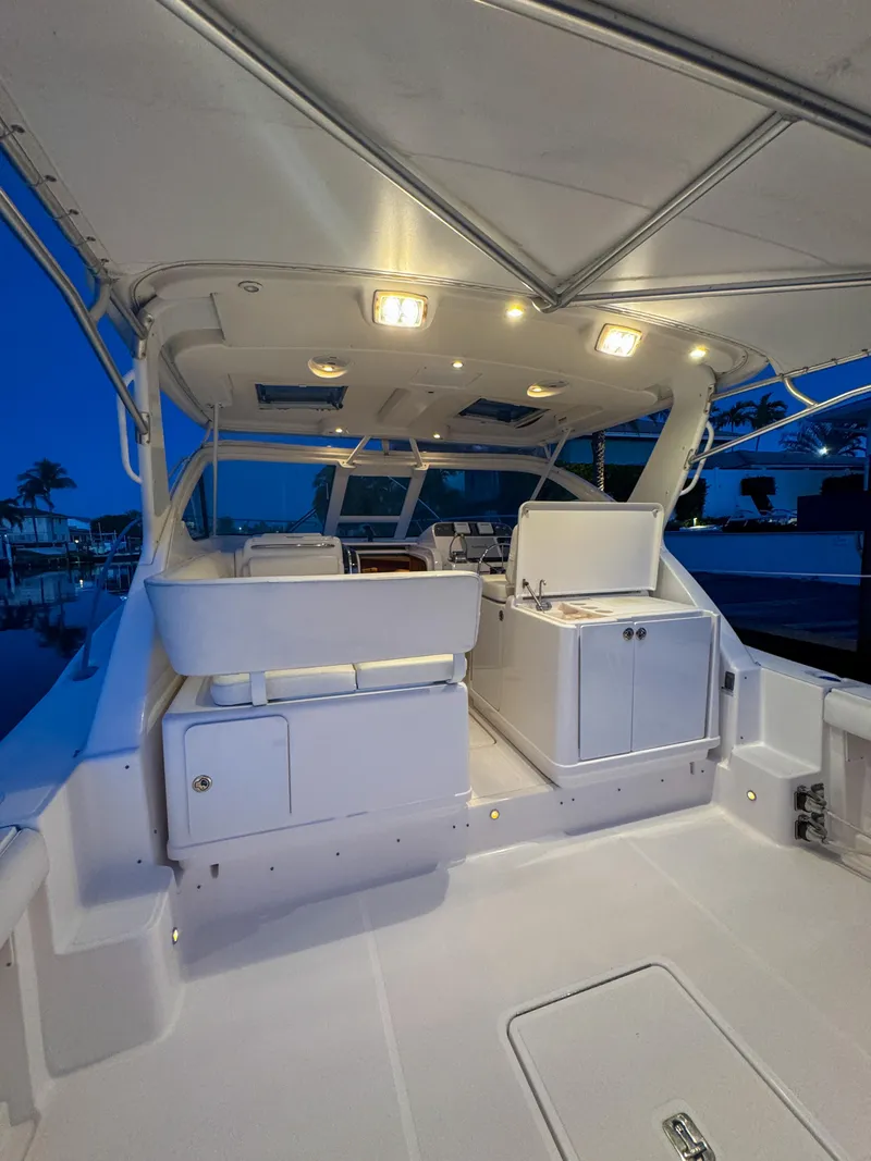 Slide: The Image of 2006 Tiara Yachts 3200 Open, illuminated deck at dusk, showcasing sleek design and spacious layout. - 25