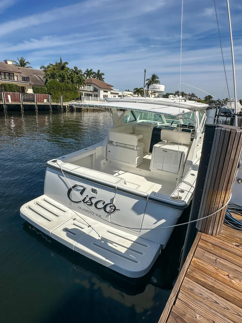 Slide: The Image of 2006 Tiara Yachts 3200 Open docked in a marina under a clear blue sky. - 3