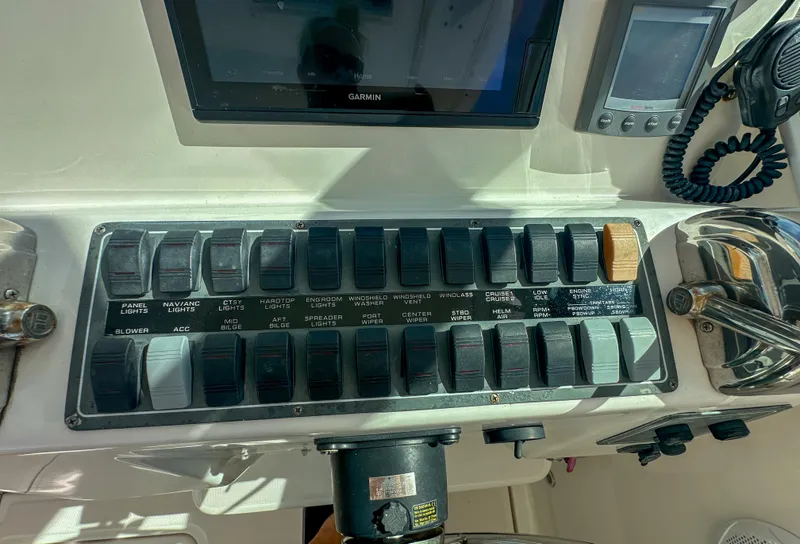 Slide: The Image of Control panel of a 2006 Tiara Yachts 3200 Open, featuring various switches and navigation equipment. - 36