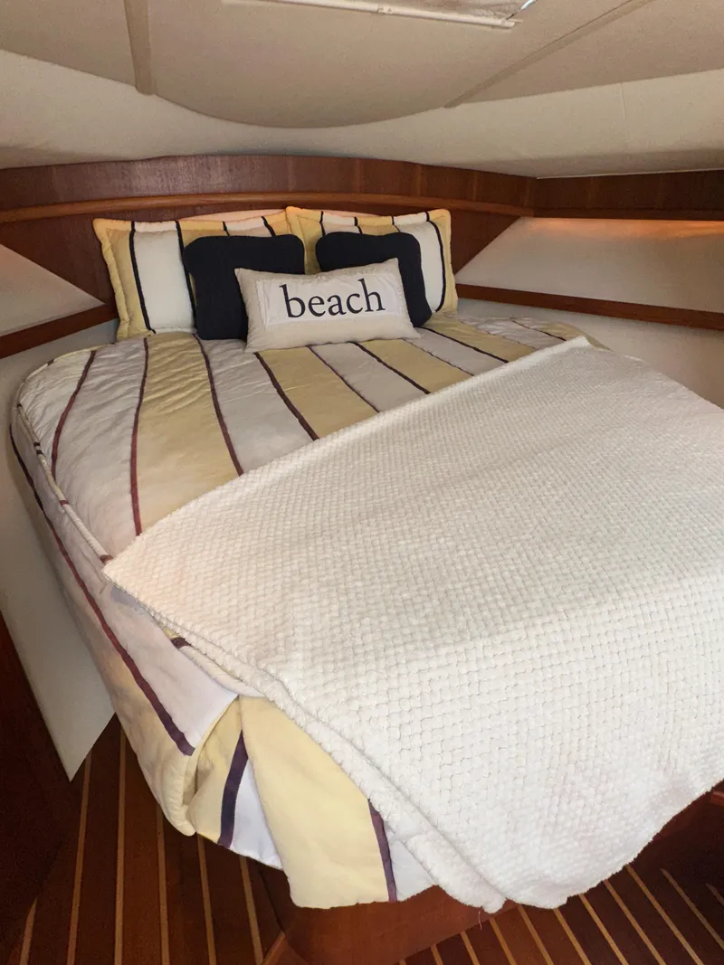 Slide: The Image of Cozy cabin interior of 2006 Tiara Yachts 3200 Open with striped bedding and "beach" pillow. - 47
