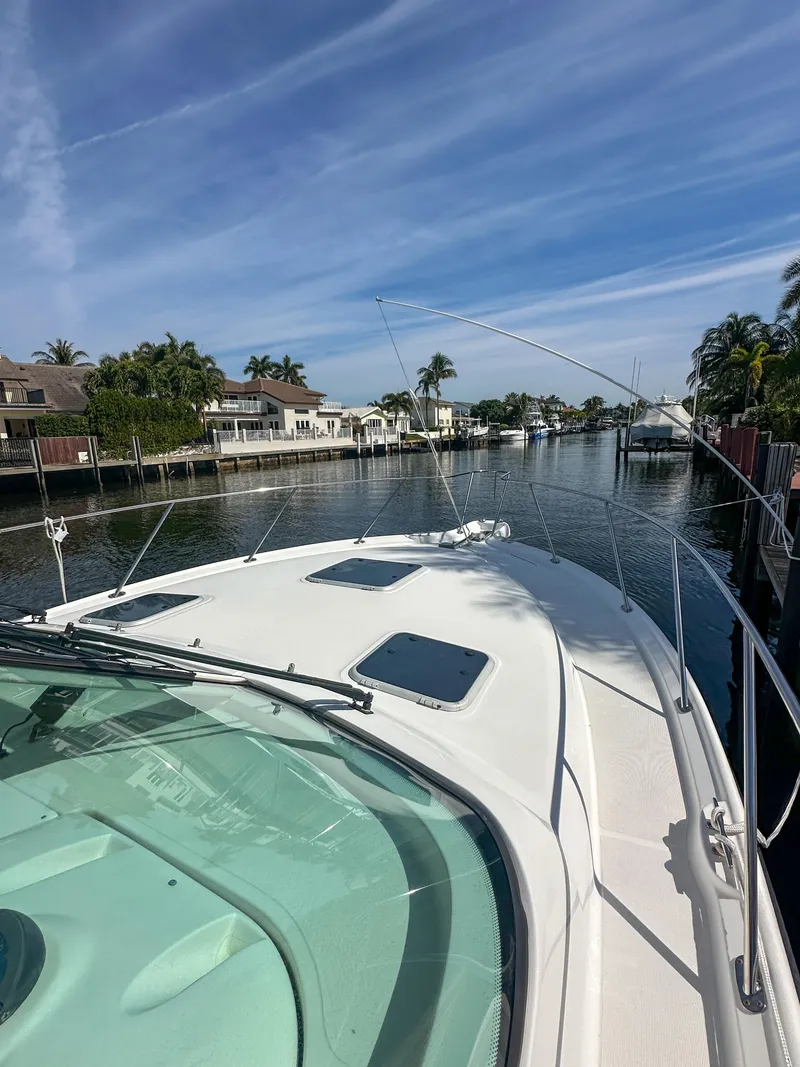 Slide: The Image of Tiara Yachts 3200 Open 2006 on a serene canal with palm trees and blue sky. - 7