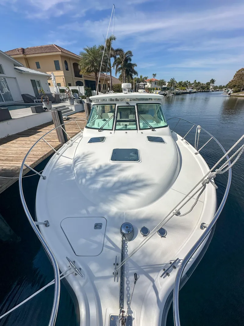 Slide: The Image of 2006 Tiara Yachts 3200 Open docked by waterfront homes under a clear sky. - 9
