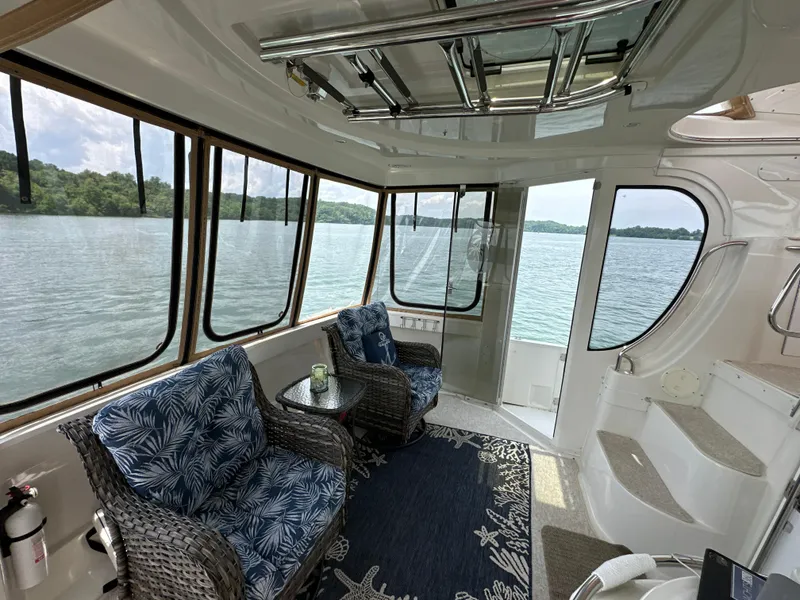 Slide: The Image of Interior of 2002 Carver 466 Motor Yacht with lake view, wicker chairs, and nautical decor. - 13