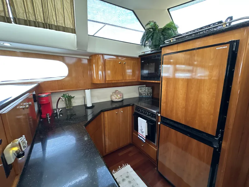Slide: The Image of Luxurious kitchen interior of 2002 Carver 466 Motor Yacht with wood cabinetry and modern appliances. - 20