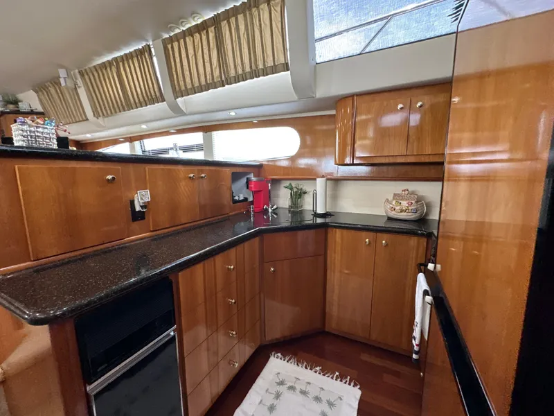 Slide: The Image of Luxurious kitchen interior of 2002 Carver 466 Motor Yacht with wood cabinetry and modern appliances. - 21
