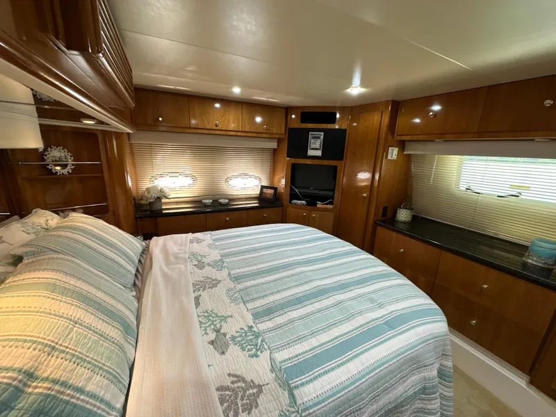 Slide: The Image of Luxurious bedroom interior of 2002 Carver 466 Motor Yacht with wood cabinetry and striped bedding. - 22