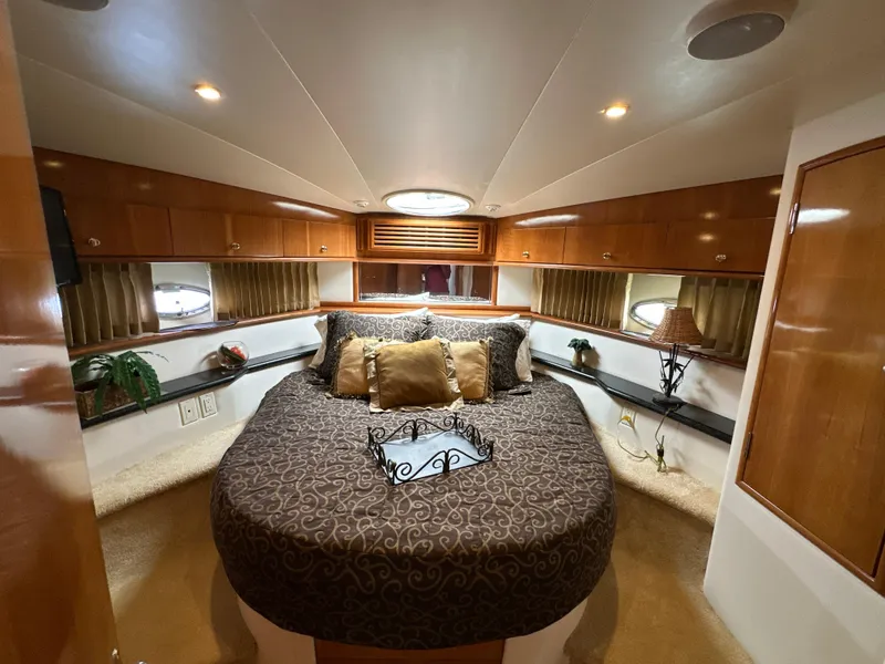 Slide: The Image of Luxurious bedroom interior of 2002 Carver 466 Motor Yacht with elegant bedding and wood accents. - 24