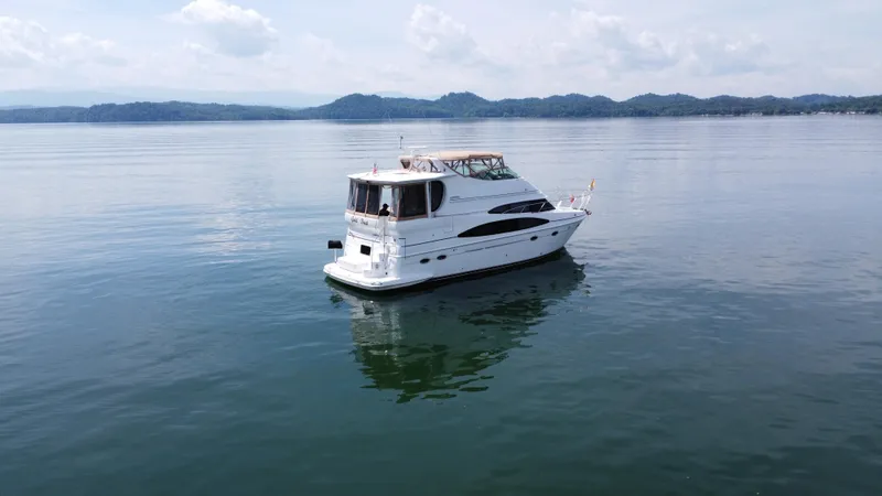 Slide: The Image of 2002 Carver 466 Motor Yacht on calm water with scenic mountain backdrop. - 5