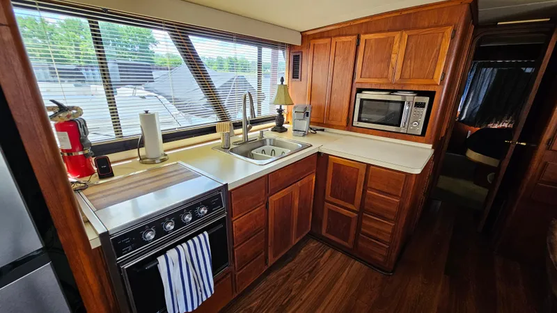 Slide: The Image of 1988 Bluewater Yachts 55 Coastal Cruiser kitchen with wood cabinets and modern appliances. - 19