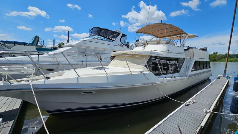 Slide: The Image of 1988 Bluewater Yachts 55 Coastal Cruiser docked under a clear blue sky. - 2