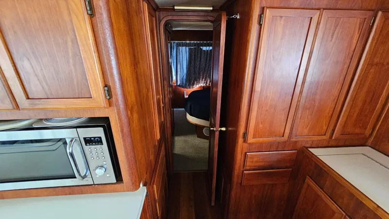 Slide: The Image of 1988 Bluewater Yachts 55 Coastal Cruiser interior with wood cabinetry and microwave. - 20