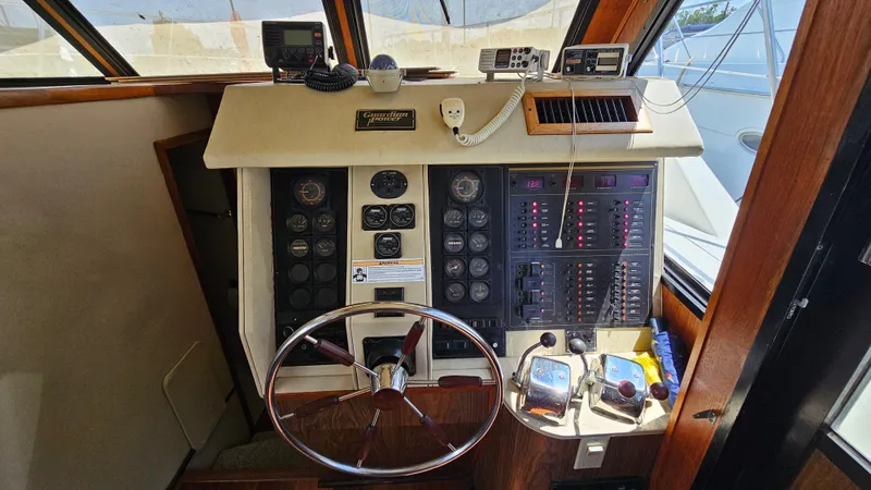 Slide: The Image of Control panel of 1988 Bluewater Yachts 55 Coastal Cruiser with steering wheel and navigation instruments. - 28