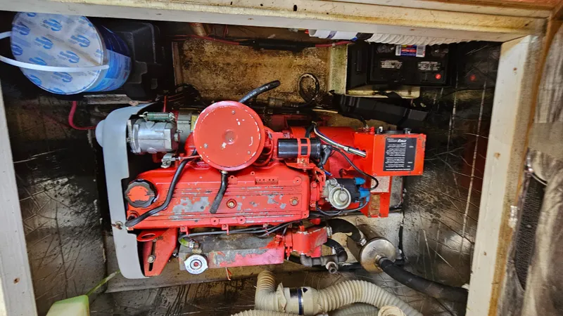 Slide: The Image of Engine compartment of 1988 Bluewater Yachts 55 Coastal Cruiser, featuring a red engine. - 36